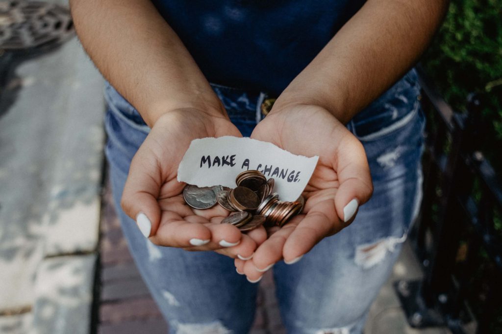 make a change - lady holding a hand full of change 